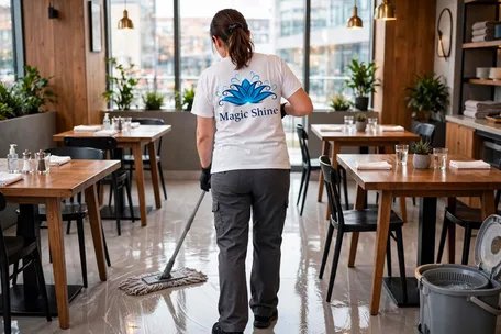 Eine Reinigungskraft von Magic Shine wischt den Boden in einem Restaurant